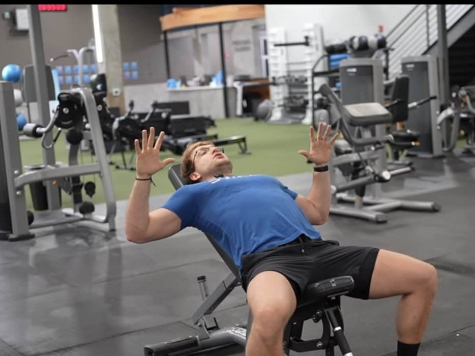Person performing a bench press in the gym